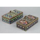 A rectangular cloisonne enamel black ground and floral patterned twin section cigarette box with