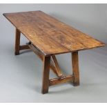 An early 20th Century 17th Century style elm trestle table, the top formed of 3 planks with H framed