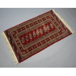 A red and white ground Bokhara rug with 9 octagons to the centre within a multi row border 156 cm