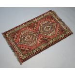 A red and black ground Afghan rug with central medallion 128cm x 81cm