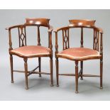 A pair of Edwardian tub back corner chairs, raised on turned supports with X framed stretchers
