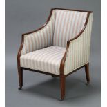 An Edwardian mahogany show frame armchair upholstered in striped material, raised on square