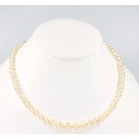 A string of cultured pearls with a 9ct yellow gold garnet and pearl clasp 42cm