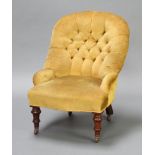 A Victorian tub back nursing chair upholstered in yellow buttoned material raised on turned supports