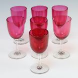 A harlequin set of 7 cranberry sherry glasses