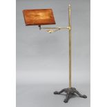 A 19th Century mahogany, brass and iron adjustable reading stand, raised on a cast iron triform base