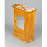 A Victorian light oak hanging bathroom cabinet enclosed by glazed mirror panelled door, the base