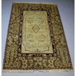 An Aubusson style brown and cream rug with central floral medallion within a 3 row border 272cm x