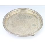 A middle Eastern silver plated tray with pierced rim on claw and ball feet 27cm