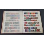 A red stock book containing British Commonwealth stamps Victoria to Elizabeth II mint and used,