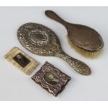 A silver backed hair brush (rubbed marks) a repousse frame, brush and paperweight