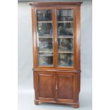 An Edwardian mahogany double corner cabinet with moulded cornice and fluted columns to the sides,