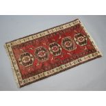 A brown, white and red ground Persian rug with 5 octagons to the centre and bird decoration 120cm