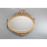 A Georgian style oval bevelled plate mirror contained in a decorative gilt frame surmounted by swag,