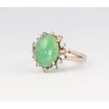 A white metal ring set with an oval jadeite stone 4.7 grams, size O 1/2, stamped 18k