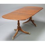 A Georgian style crossbanded mahogany twin pillar dining table with 1 extra leaf 73cm h x 91cm w x