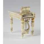 A 19th Century carved ivory miniature model of a piano forte 6cm 1 finial is missing and there are