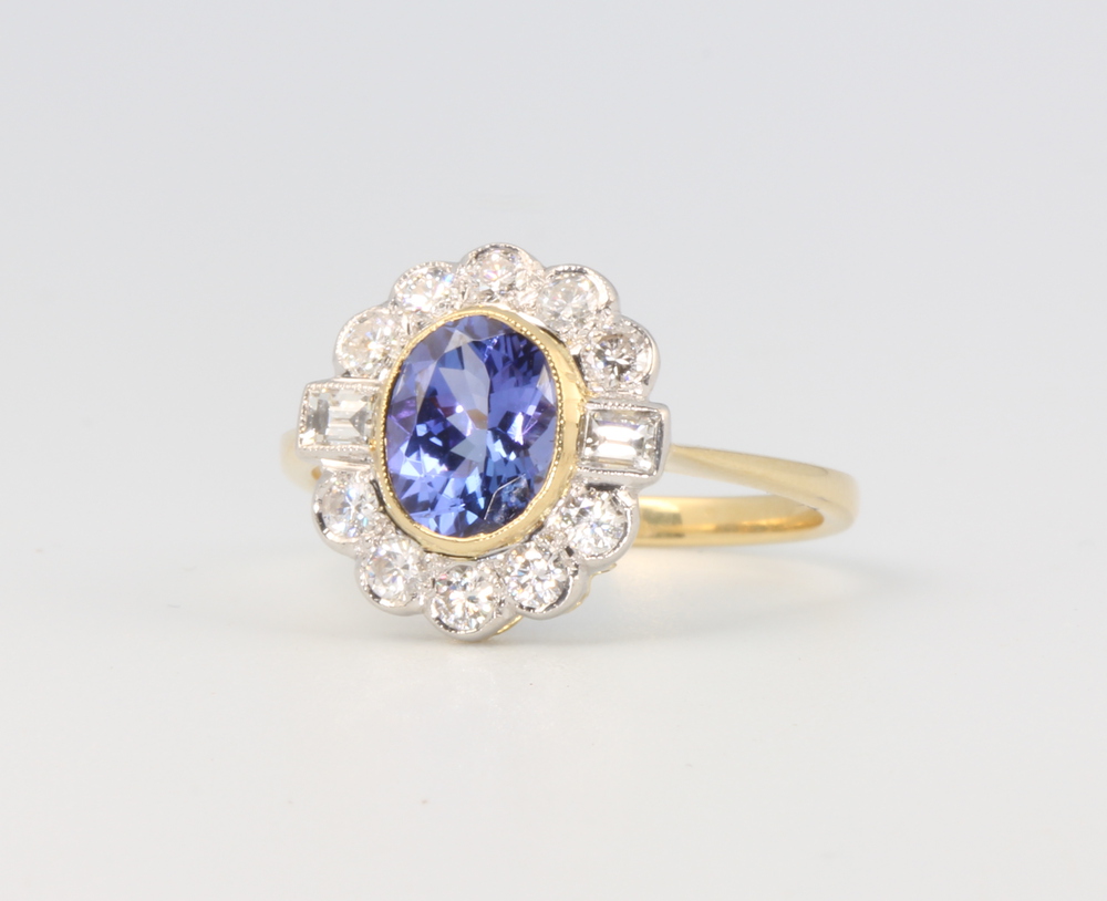 An 18ct yellow gold oval tanzanite and diamond cluster ring, the centre oval cut stone 1.45ct, the