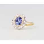 An 18ct yellow gold oval tanzanite and diamond cluster ring, the centre oval cut stone 1.45ct, the