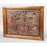 A Chinese carved hardwood panel decorated figures before pagodas 38cm x 49cm