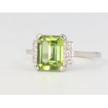 A platinum peridot and diamond cocktail ring, the centre stone 2ct, flanked by 6 brilliant cut