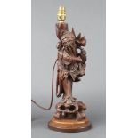 A Chinese carved root wood table lamp figure of a standing gentleman with ivory teeth, raised on