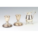 An Edwardian silver cream jug with paw feet Birmingham 1902, 6cm, 50 grams and a pair of dwarf