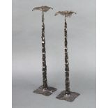 A pair of Art Nouveau style hammered iron pricket candlesticks with leaf shaped sconces and bases