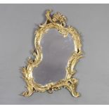 A 19th/20th Century shaped plate mirror contained in a rococo style gilt frame 52cm x 34cm