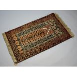 A brown and black ground Afghan prayer rug within multi row border 141cm x 86cm