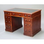 A Victorian mahogany kneehole pedestal desk with inset writing surface above 1 long and 8 short