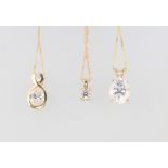 Three 14ct yellow gold chains with paste set pendants, 5.5 grams