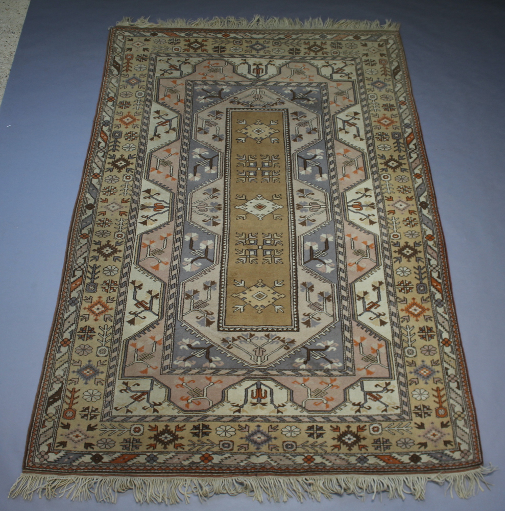 A Caucasian style brown and blue ground rug with central medallion within a multi-row border 297cm x