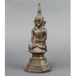 A bronze figure of a seated buddha raised on a shaped base 25cm x 10cm x 9cm