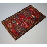 A blue and red ground Baluch rug with floral decoration 140cm x 84cm