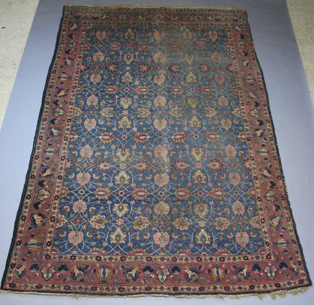 A blue, pink and green ground Persian carpet with all over floral design 387cm x 263cm Heavily