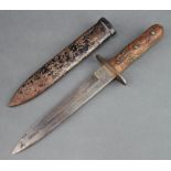 An Italian WW2 combat knife with 20cm blade, carved wooden grip and metal scabbard