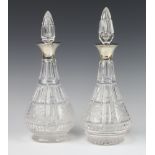 A near pair of cut glass mallet shaped decanters and stoppers with silver collars Birmingham 1936