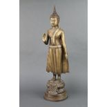 An Eastern bronze figure of a standing Buddha raised on a circular base 59cm x 16cm