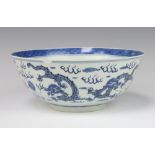 An 18th Century style Chinese blue and white bowl decorated with a band of dragons chasing the