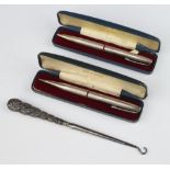 Two cased silver engine turned yard o led propelling pencils together with a silver handled button