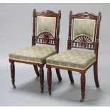 A pair of Victorian mahogany dining chairs, the seats and backs upholstered in green floral material