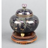 A black ground Japanese cloisonne jar and cover of melon form decorated birds amidst branches,