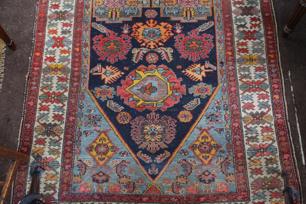A North West Persian red and blue ground rug with shaped medallion to the centre within a multi - Image 3 of 5