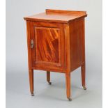 An Edwardian inlaid and crossbanded mahogany bedside cabinet with raised back, enclosed by a