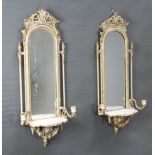 A pair of 19th Century arched plate mirrors contained in a gilt and white painted plaster frames,