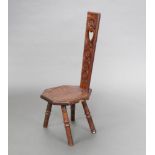 A Victorian carved oak spinning chair with solid back and heart decoration, raised on turned