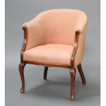 An Edwardian mahogany framed tub back chair upholstered in orange material, raised on cabriole