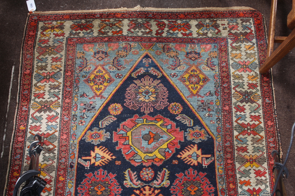 A North West Persian red and blue ground rug with shaped medallion to the centre within a multi - Image 4 of 5