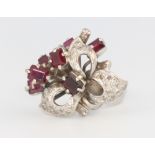 A white metal stamped 18k, ruby and diamond scroll ring 6.7 grams, size L 1/2, with original